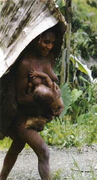 Im Gehen stillende Mutter in Papua-Neuguinea